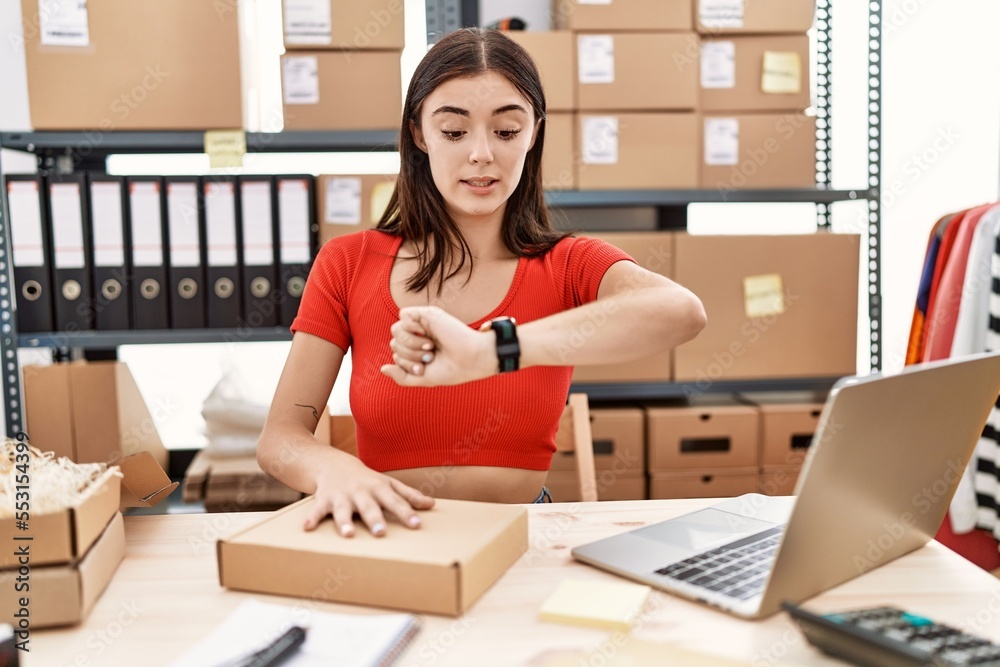 Canvas Prints young hispanic woman preparing order working at storehouse looking at the watch time worried, afraid