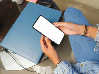 Close-up of a woman hand holding a smartphone white screen is blank .Mockup.