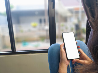 Close-up of a woman hand holding a smartphone white screen is blank .Mockup.