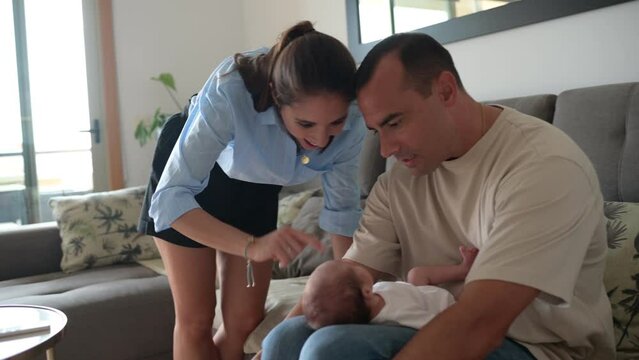 Parents cooing and playing with infant