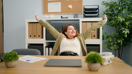 Young redhead woman business worker relaxed with hands on head at office