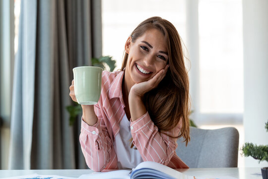 Young Business Women In The Office Drinking Coffe And Looking At The Camera