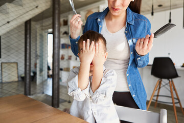 Child holds his hands in front of his face at the hairdresser