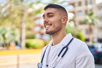 Young hispanic man doctor smiling confident standing at park