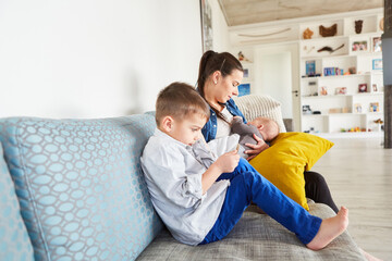 Mother breastfeeding baby on sofa