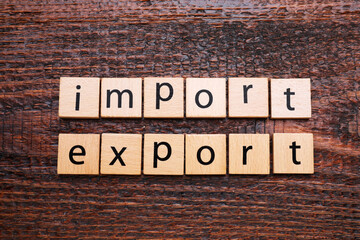 Fototapeta premium Words Import and Export made of cubes on wooden table, top view