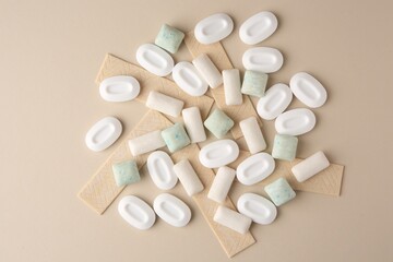Many different chewing gums on beige background, flat lay