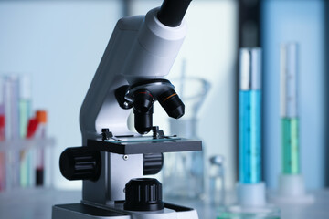 Closeup view of modern microscope with glass slide in laboratory. Space for text
