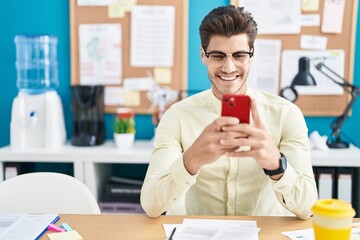 Young hispanic man business worker using smartphone working at office