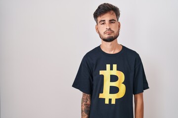 Young hispanic man with tattoos wearing bitcoin t shirt looking sleepy and tired, exhausted for...