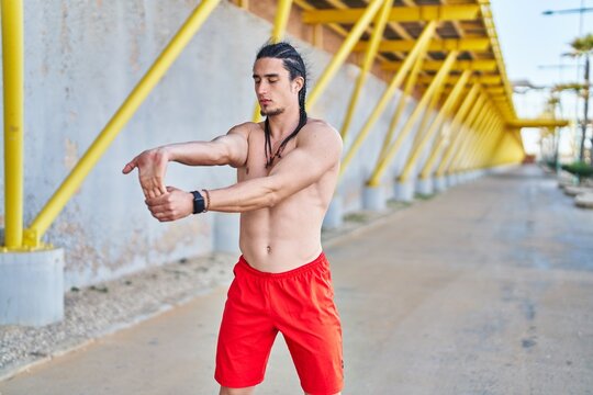 Young man stretching arms at street