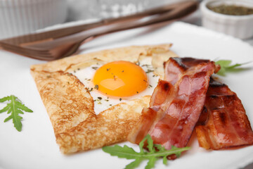Delicious crepe with egg on white plate, closeup. Breton galette