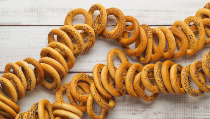Bunch of delicious ring shaped Sushki (dry bagels) on white wooden table, top view