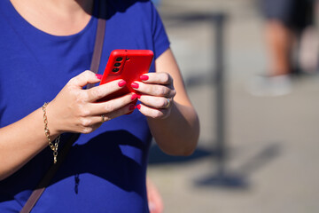 detail of hands holding a mobile phone. woman writing a message on the phone.