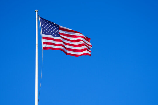 american flag with clear blue sky. photo during the day.