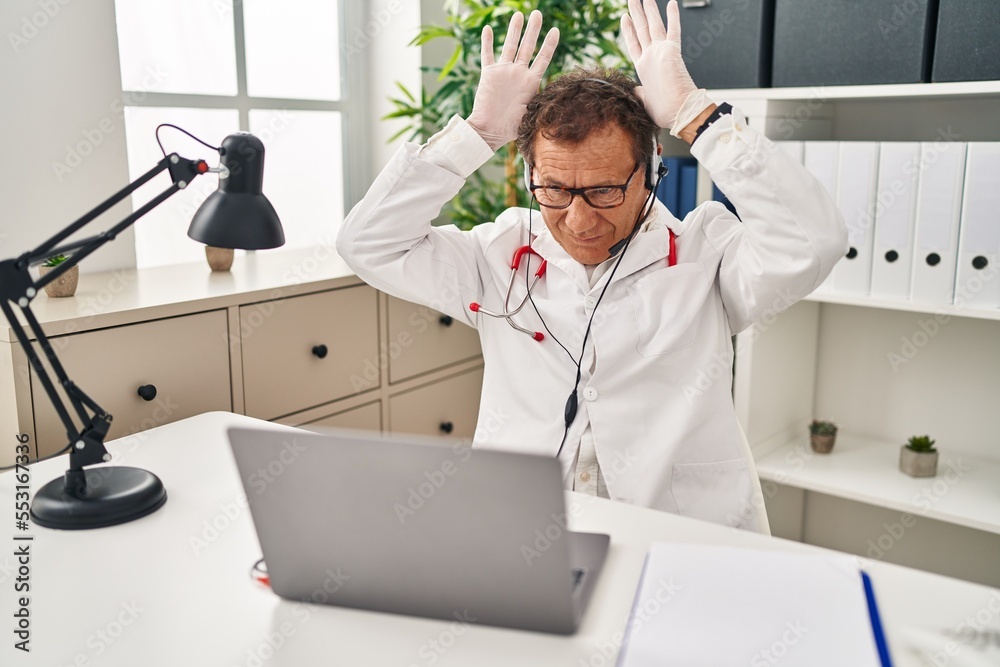 Sticker senior doctor man working on online appointment doing bunny ears gesture with hands palms looking cy