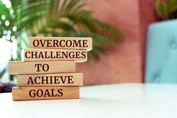 Wooden blocks with words 'Overcome challenges to achieve goals'.