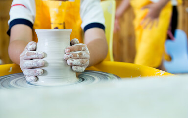 Young boy making a pitcher of clay