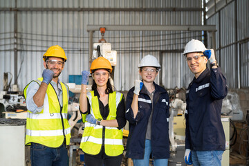 Group of male and female engineer worker working together and control automatic robot arm system welding in the industry factory