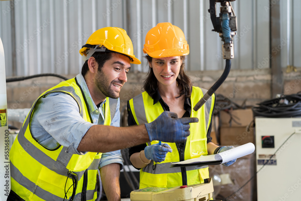 Aufkleber Two male and female engineer checking and maintenance robot arm in the workshop. Team of technician worker working with control automatic robot arm system welding in the industry factory