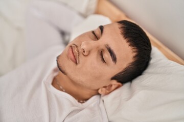 Fototapeta na wymiar Young man lying on bed sleeping at bedroom