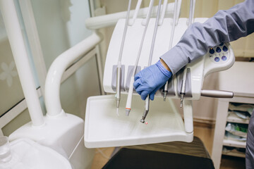 Close up of a dentist's hands picking up the instruments to start a check-up. dental health