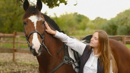 A young woman rider prepares a horse for a competition. Communication with your horse. Show jumping woman equestrian training.