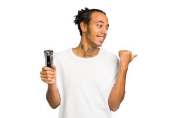 Young African American man holding a razor isolated points with thumb finger away, laughing and carefree.