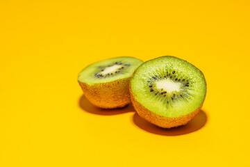 kiwi fruit on yellow background - obrazy, fototapety, plakaty