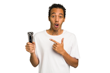 Young African American man holding a razor isolated pointing to the side