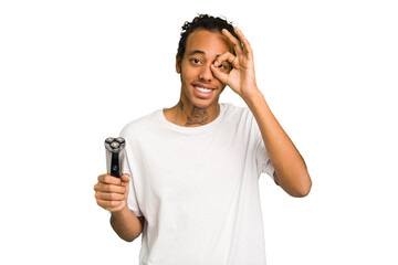 Young African American man holding a razor isolated excited keeping ok gesture on eye.