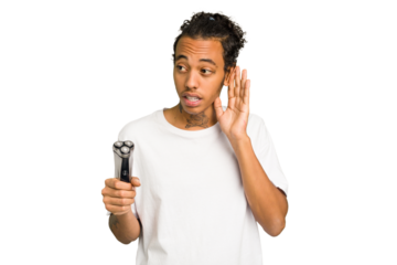 Young African American man holding a razor isolated trying to listening a gossip.