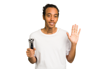 Young African American man holding a razor isolated smiling cheerful showing number five with fingers.