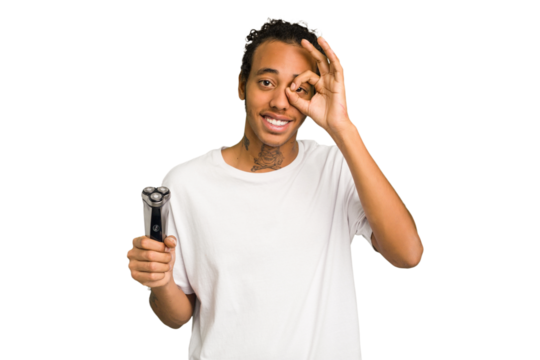 Young African American man holding a razor isolated excited keeping ok gesture on eye. - Powered by Adobe