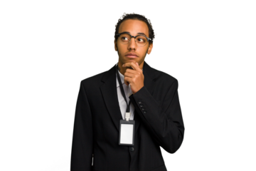 Young African American business man with badge isolated looking sideways with doubtful and skeptical expression.