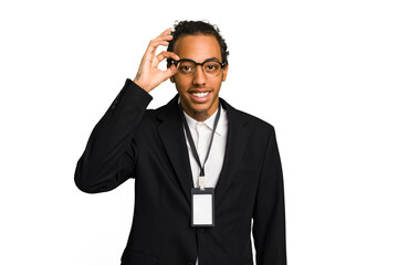 Young African American business man with badge isolated excited keeping ok gesture on eye.