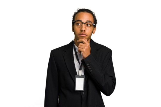 Young African American business man with badge isolated looking sideways with doubtful and skeptical expression.