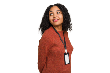Young african american woman with ID card isolated looks aside smiling, cheerful and pleasant.