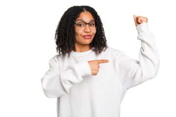 Young african american woman with curly hair cut out isolated showing strength gesture with arms, symbol of feminine power