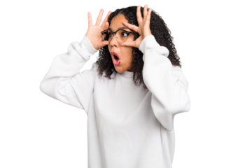 Young african american woman with curly hair cut out isolated keeping eyes opened to find a success opportunity.