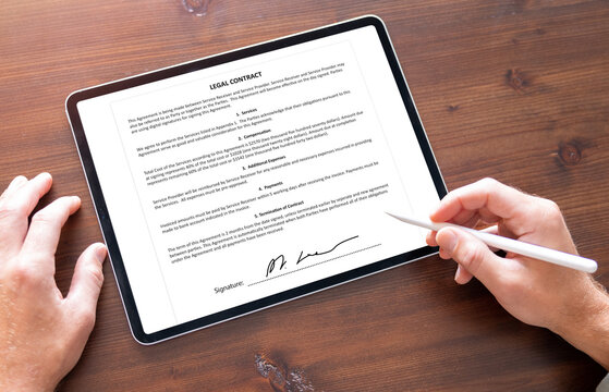 Man signing document on tablet computer