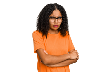 Young african american woman with curly hair cut out isolated frowning face in displeasure, keeps arms folded.