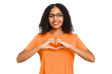 Young african american woman with curly hair cut out isolated smiling and showing a heart shape with hands.