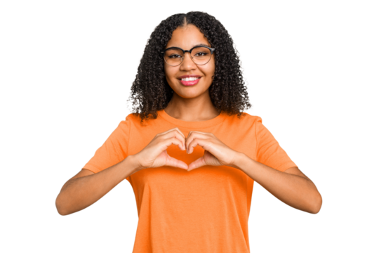 Young african american woman with curly hair cut out isolated smiling and showing a heart shape with hands.