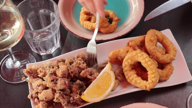 Popular appetizer of Spanish cuisine is squid a la romana and baby andalusian squids served with a slice of lemon. High quality 4k footage