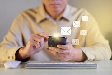 Businessman hands using smartphone on office table surfing the internet with email icon, email marketing concept, send e-mail or news letter, online working internet network