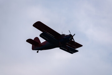 AIRPLANE - The biplane flies against sky with clouds