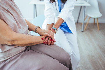 Obraz premium Cropped shot of an unrecognizable female nurse comforting a patient in the hospital. Health worker holding patient's hand. Cropped shot of a senior woman holding hands with a nurse