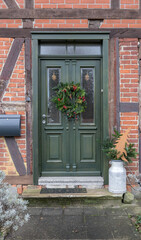 Fototapeta na wymiar Wooden door of a half-timbered house decorated for Christmas