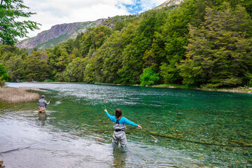 a woman is trying to fish trout in nahuel huapi lake, argentina
